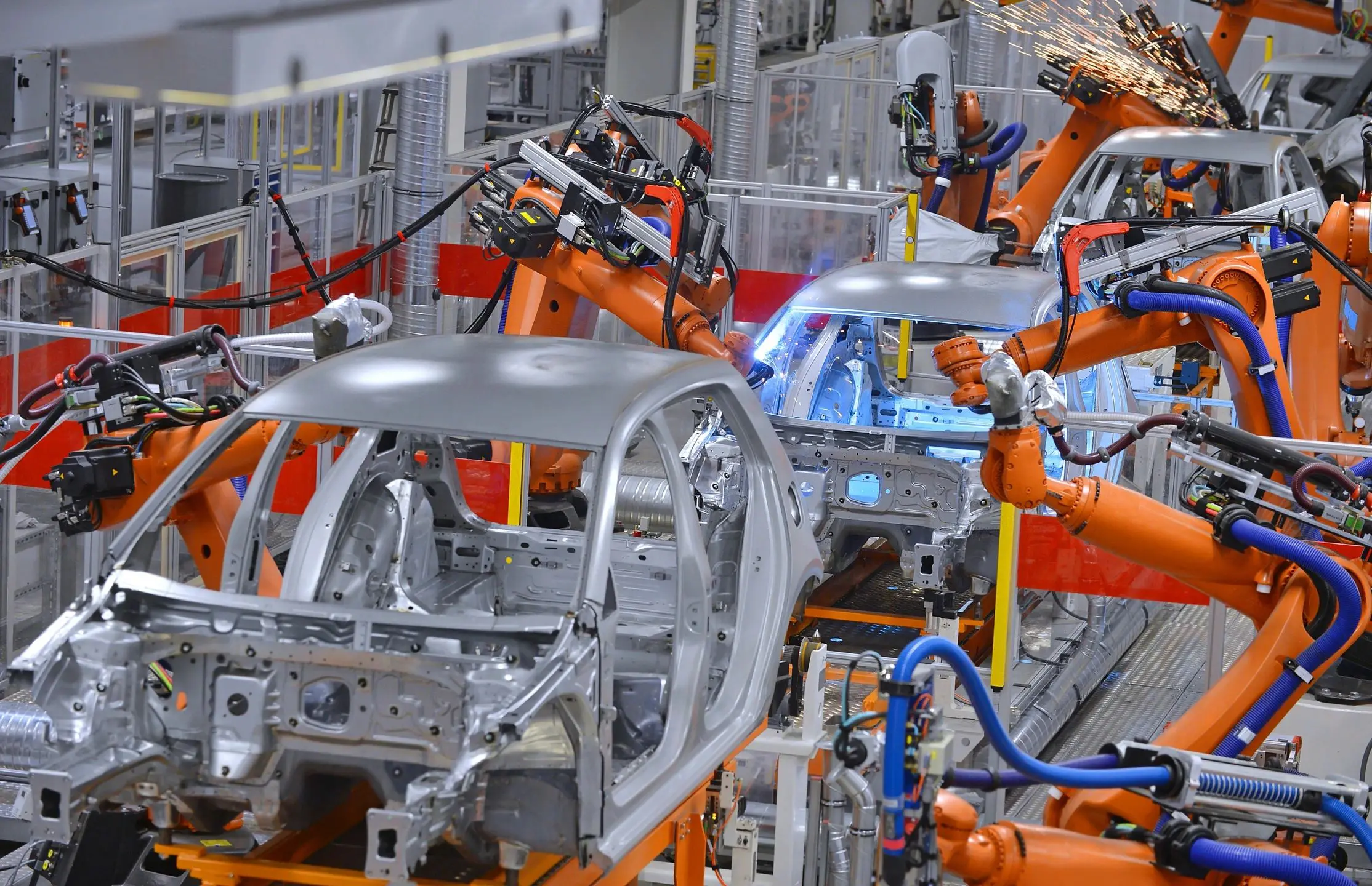 A factory with robots and cars on the assembly line.